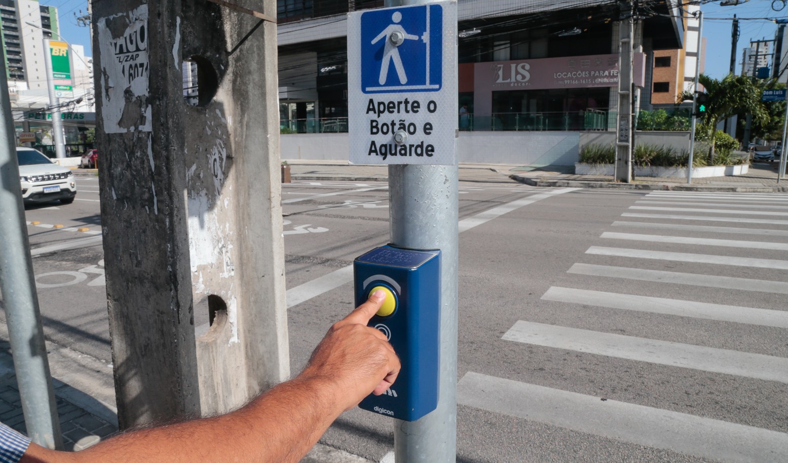 homem aperta botão de semáforo para pedestre